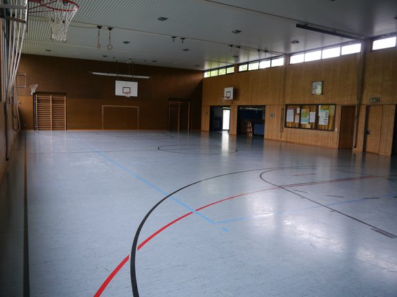 Turnhalle mit einem blauen Spielfeld und Basketballkörben