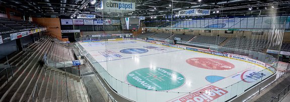 Eine Eishockeyarena von innen mit Tribüne und großer Eisfläche