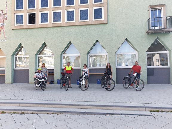 Fünf E-Bikes vor dem Rathaus Schwenningen mit sechs Testfahrern.