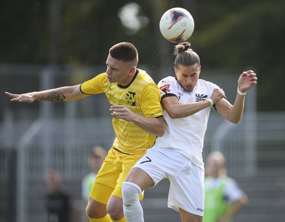 zwei Fußballspieler in einem Kofpballduell um den Ball