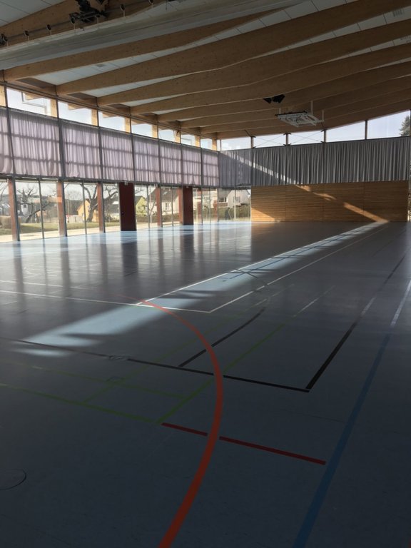 Turnhalle mit blauem Spielfeld und Basketballkörben