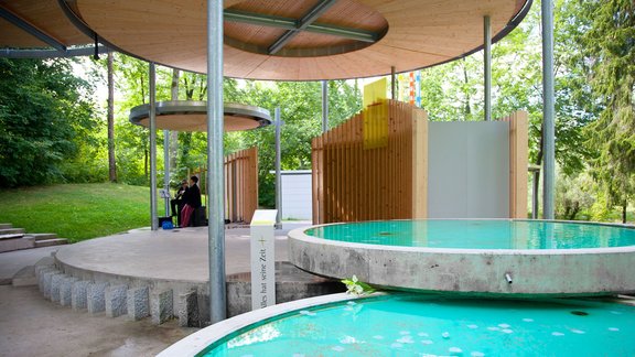 großer überdachter Pavillon mit zwei Wasserbecken im Vordergrund