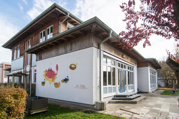 Gebäude, in dem sich der Kindergarten Marbach befindet mit bunter Malerei an der Fassade.