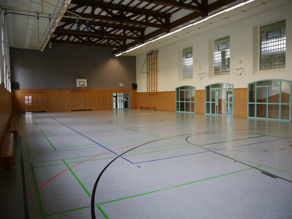 Spielfeld einer Turnhalle mit Basketballkörben