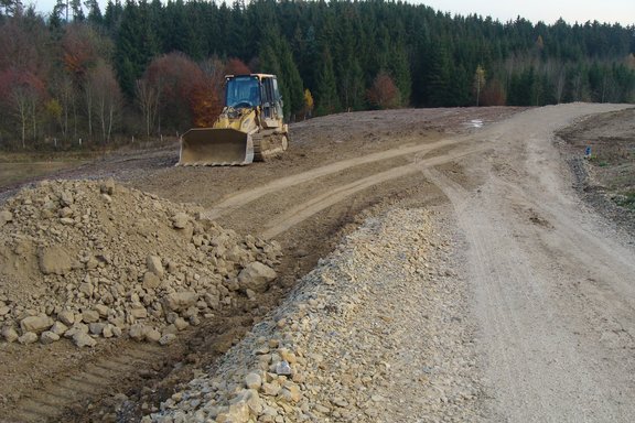 Ein Bagger fährt auf der Erddeponie.