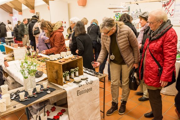 Personen schauen sich einen Stand auf dem Kunsthandwerkermarkt an