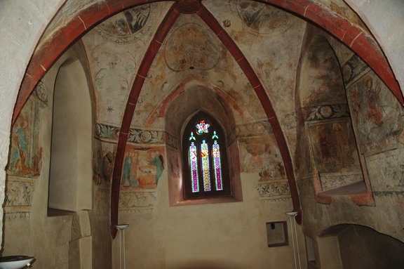 Malereien in Turmkapelle und buntes Glasfenster.