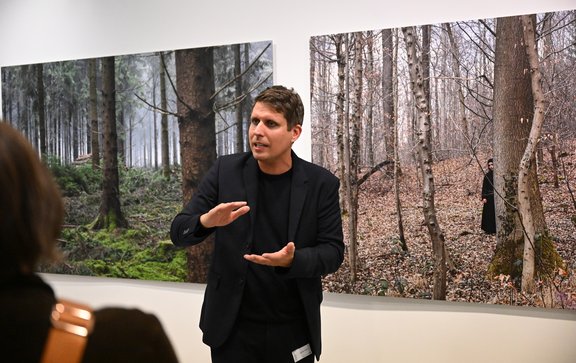 Stephan Rößler erläutert die Arbeiten aus der Serie 'woanders' von Ferhat Ayne