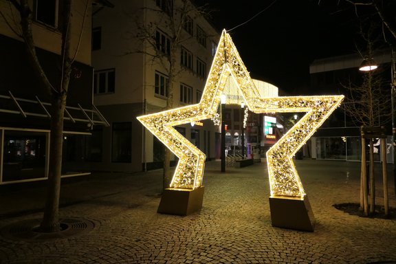 Ein Stern mit insgesamt fünf Zacken, wobei die unteren Zacken als Träger des Sterns dienen, so dass der Stern einen Bogen bildet