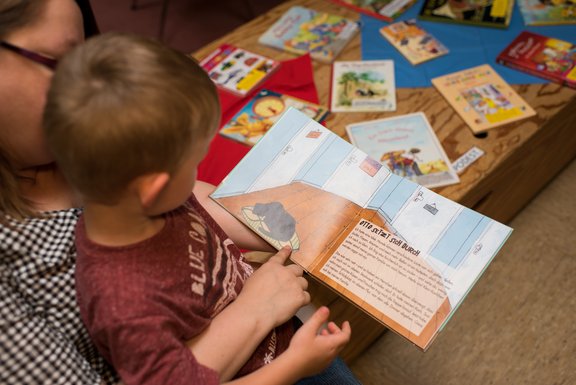 Erzieherin liest Kind ein Buch vor