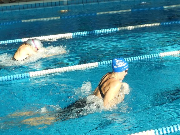 zwei Schwimmerinnen in einem 100m-Rennen im Bruststil