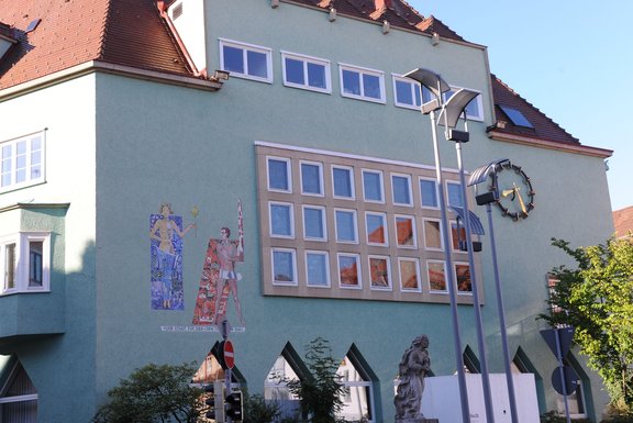 ein Haus mit grüner Fassade und großer Uhr