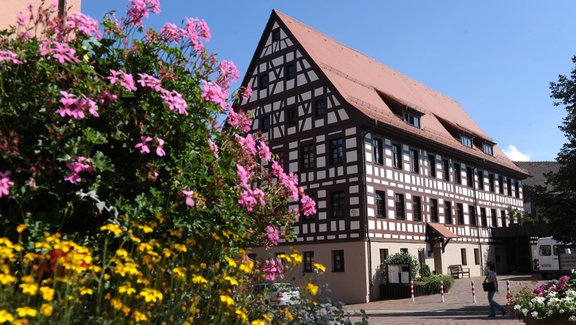 ein altes Fachwerkhaus mit bunten Blumen im Vordergrund