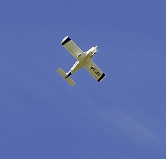 Ein fliegendes Modellflugzeug vor blauem Himmel