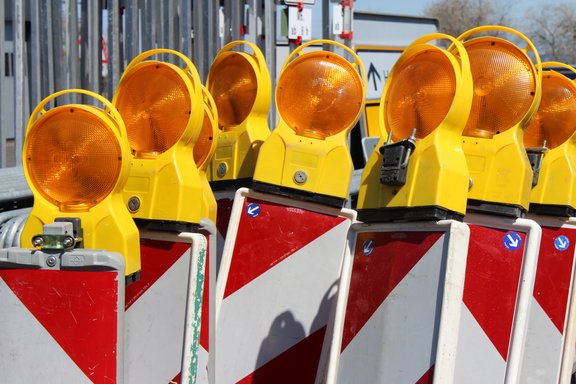 Viele Baustellen-Warnleuchten stehen dicht beieinander.