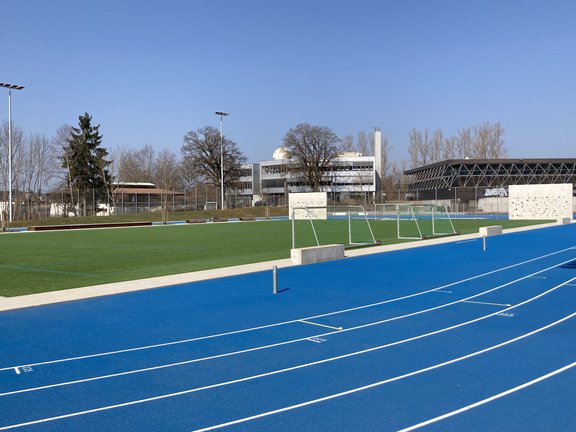 Kunstrasen-Fußballplatz umrundet von einer blauen Laufbahn