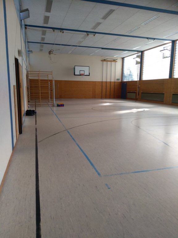 Turnhalle mit Basketballkorb und einer Sprossenwand