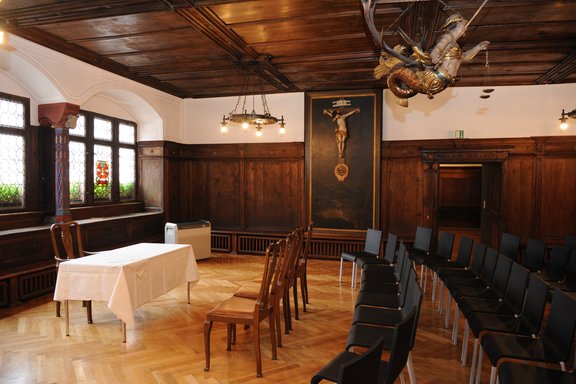 Ein alter Saal ist für eine Hochzeit mit Stühlen und Tisch ausgestattet.