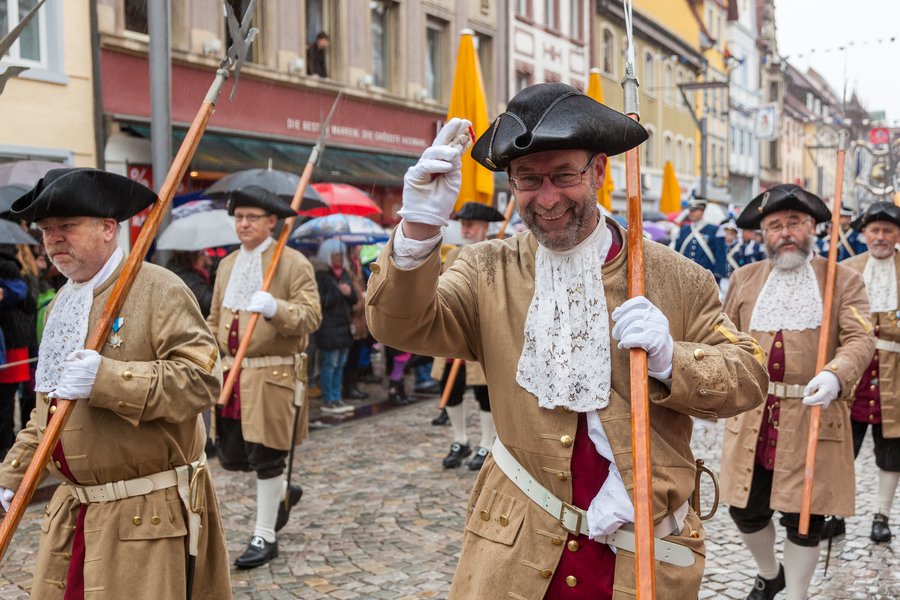 Die Miliz setzt die Tradition der Bürgersoldaten fort, deren Wurzeln bereits im 13. Jahrhundert sind, als die Handwerkszünfte die Träger der Stadtverteidigung waren.